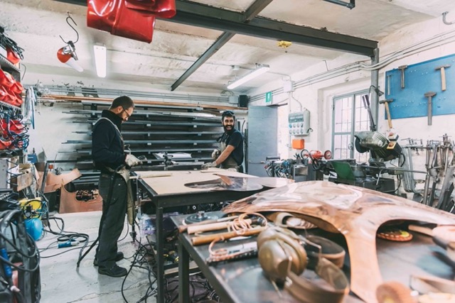 two-metalworkers-working-at-forge-workbench-Porsche 928