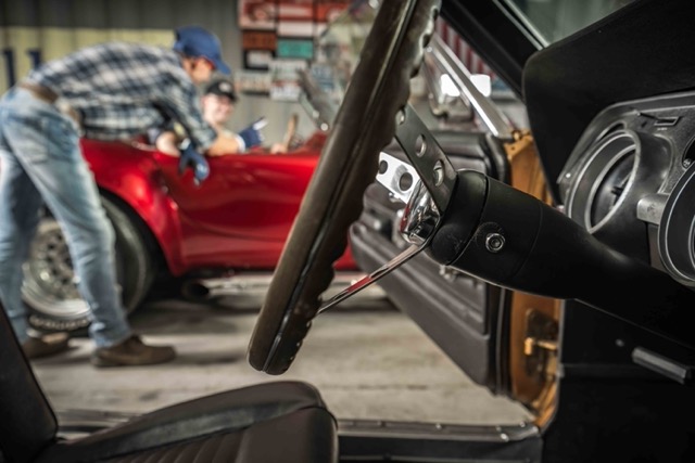 worker-in-garage-discussing-with-customer-red-car-out-of-focus-Porsche 928