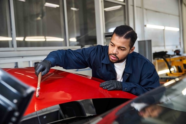 handsome-young-mechanic-skillfully-working-on-a-vehicle-Porsche 928