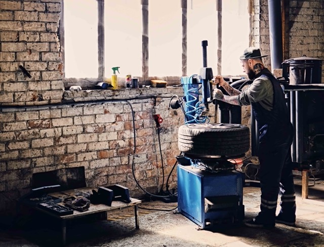 bearded-mechanic-changing-car-s-tire-on-a-tire-Porsche 928