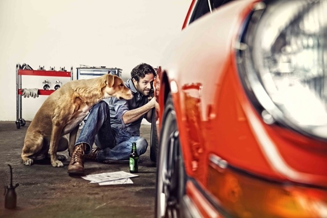 man-and-dog-inspecting-red-convertable-in-home-garage-Porsche 928