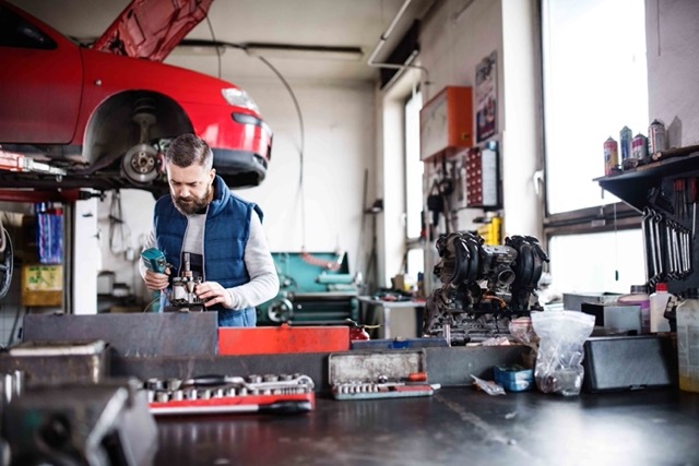 man-mechanic-repairing-a-car-in-a-garage-Porsche 928